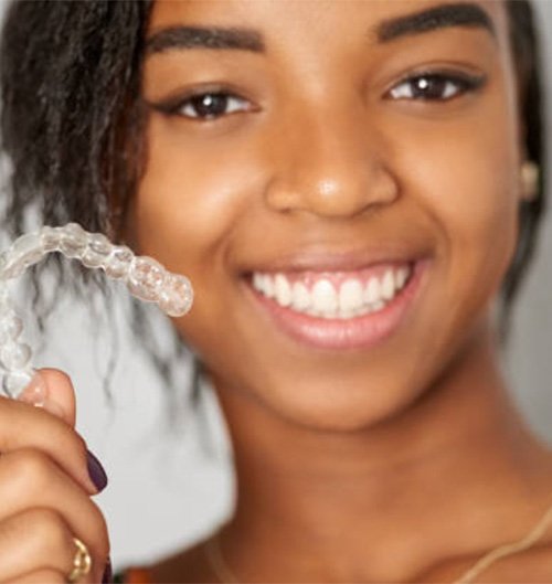 Close up of woman holding a clear aligner