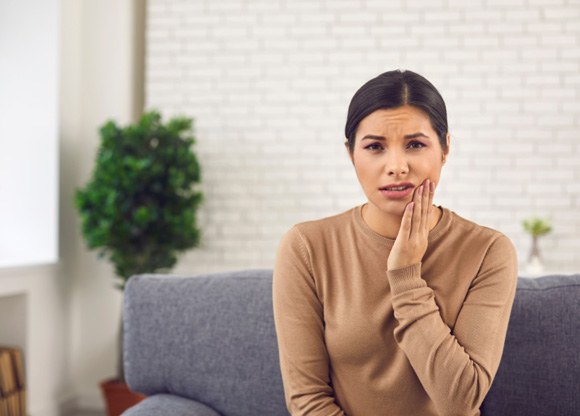 Patient in Mount Prospect holding cheek at dentist