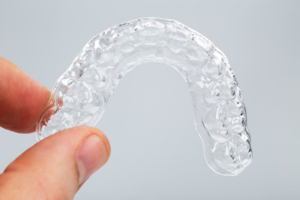 Close up of patient holding a clear retainer